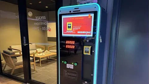 Betalingsterminal montert på vegg, med skjerm.