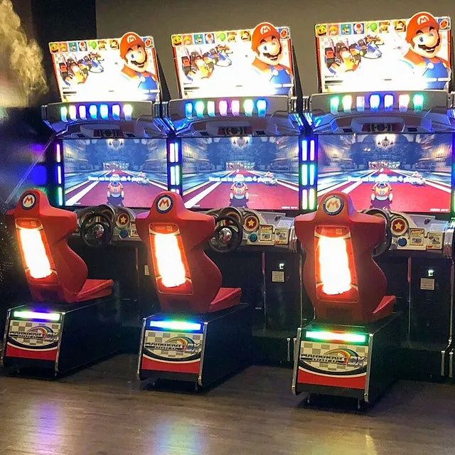 Fargerike arkademaskiner med skjermer og lys.