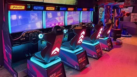 Fargerike motorsykkelspill står på rekke i en opplyst arkade.