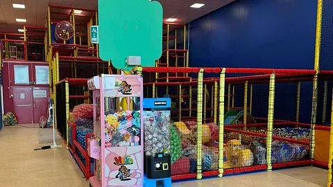 To små maskiner med bamser og leker plassert i et fellesområde.