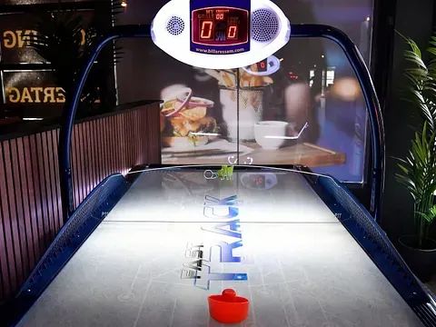 Luft-hockeybord med elektronisk poengtavle og blinkende lys.