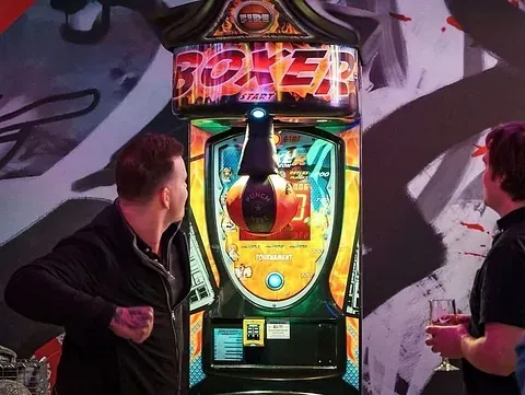 To menn spiller på boksemaskin.