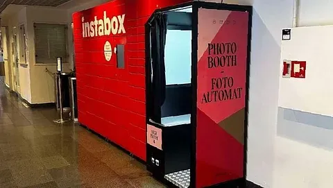 Rød fotoboks plassert i korridor.